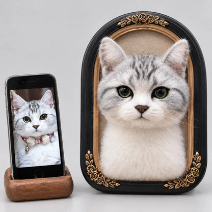 Custom 3D felted silver tabby cat portrait in a black oval frame with gold floral details, beside the original cat photo on a phone.