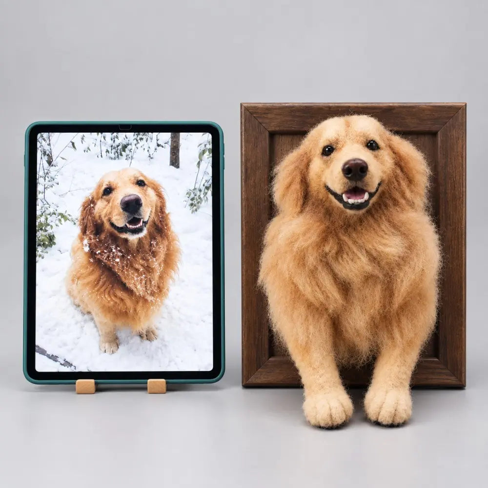 Custom 3D needle felted Golden Retriever dog portrait in a wooden frame next to a tablet displaying the original dog photo in snow